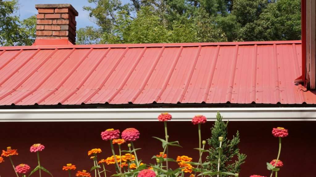 Red metal roof complimented by flowers